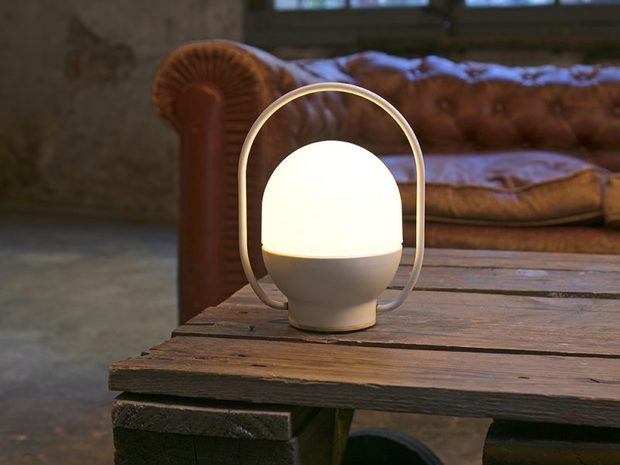 Lámpra blanca sobre mesa de palets de madera y sofá chester marrón diariodesign