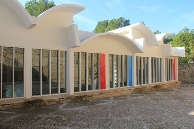 fachada norte hormigón blanco arcos movimiento moderno puertas carpintería rojo y azul taller sert miró diariodesign