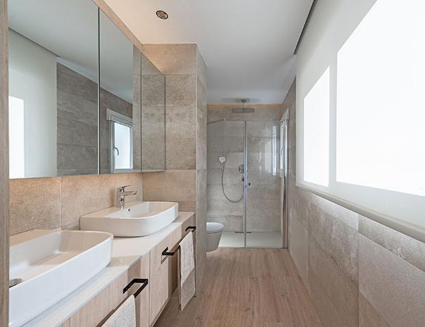 El baño principal del apartameto stá realizado con Silestone un porcelánico en tono piedra para el suelo y muebles hecho a medida