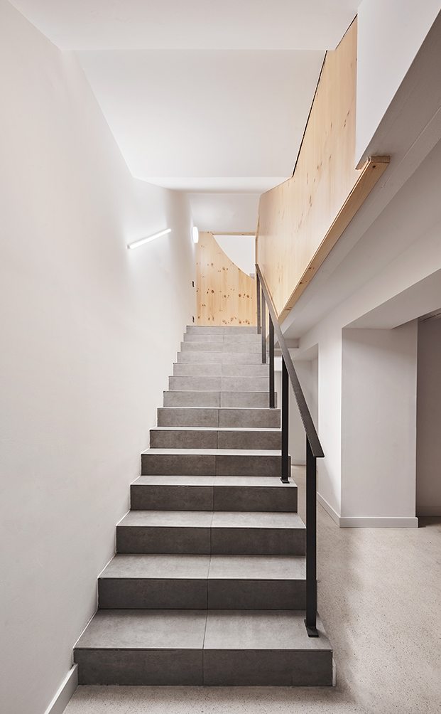 Unas discretas escaleras llevan a la planta sótano de la clínica dental Impress dedicada a servicios