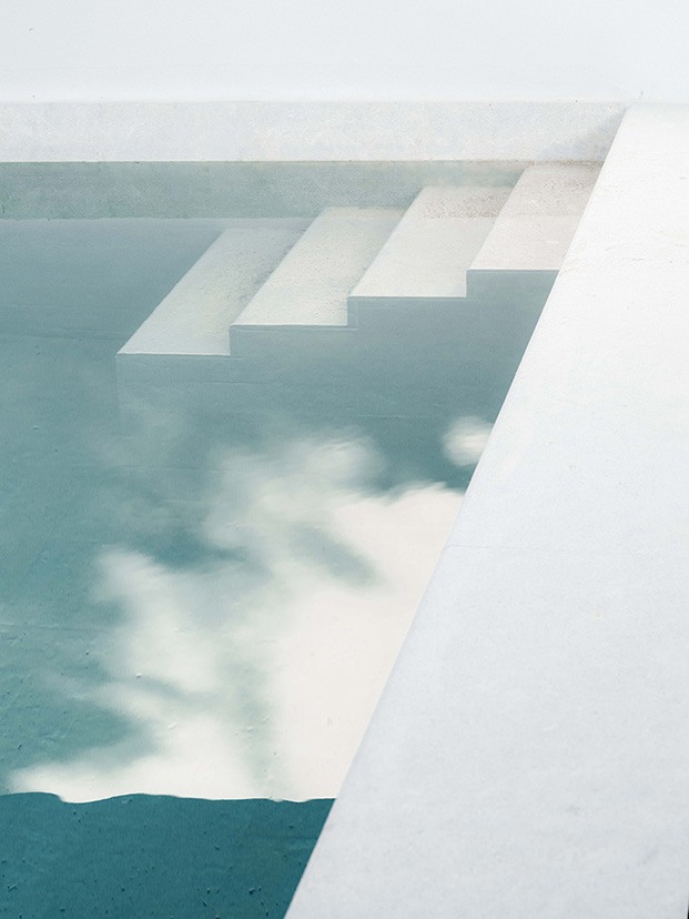 Detalle de la piscina de la vivienda diseñada por Company Studio con baldosas de piedra natural
