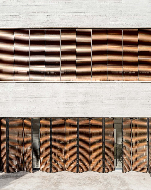 Unas persianas tipo acordeón diseño de Company Studio permiten aislar y separar los distintos espacios de la vivienda