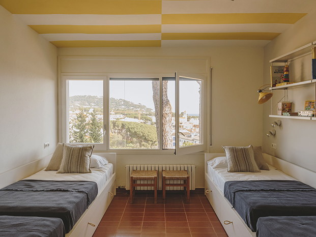 Para dar un aire nuevo a los dormitiorios de esta casa en la playa, Isabel López Vilalta ha creado toques de color en los techos