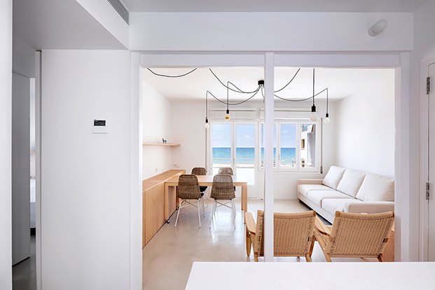 La vista del mar protagoniza el salón comedor en el apartamento de playa de ALtafulla. Al fondo la terraza que es el corazón de la casa.