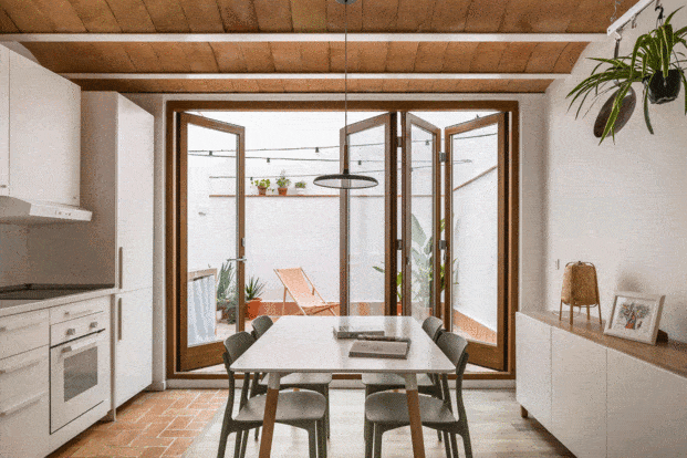Una puerta plegable en acordeón comunica la cocina con el patio y desdibuja los límites entre interior y exterior