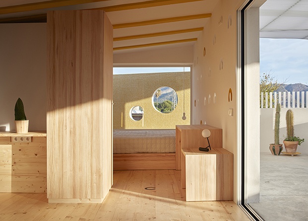 La madera protagoniza el interior del pequeño refugio que se abre al patio y al campo