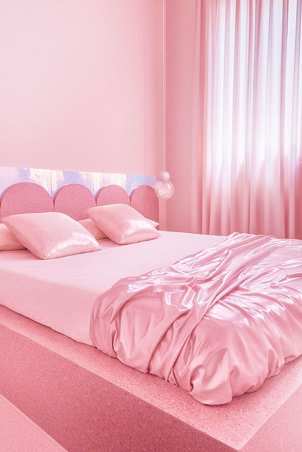 Un cabecero festoneado protagoniza el segundo dormitorio del piso de alquiler en Madrid, también decorado en rosa