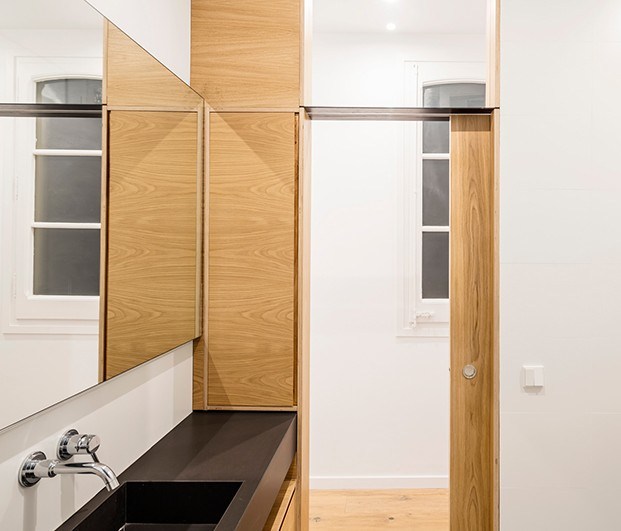 En el baño de este pequeño piso en Barcelona, una ventana superior deja paso a la luz y da amplitud visual