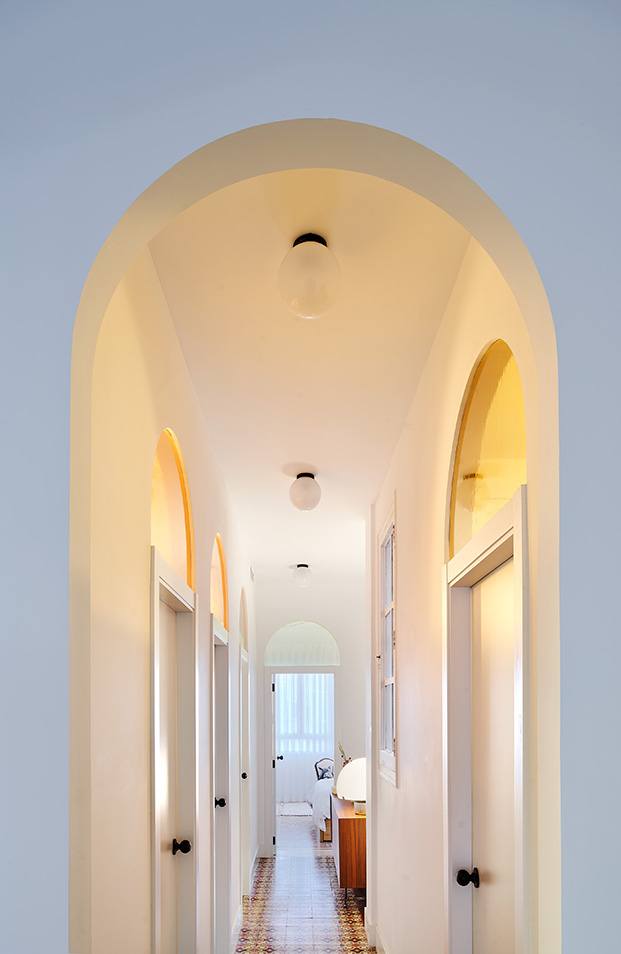 Vista del pasillo y las puertas en forma de arco con sus cristales fijos en ámbar. Al fondo se distingue el dormitorio principal