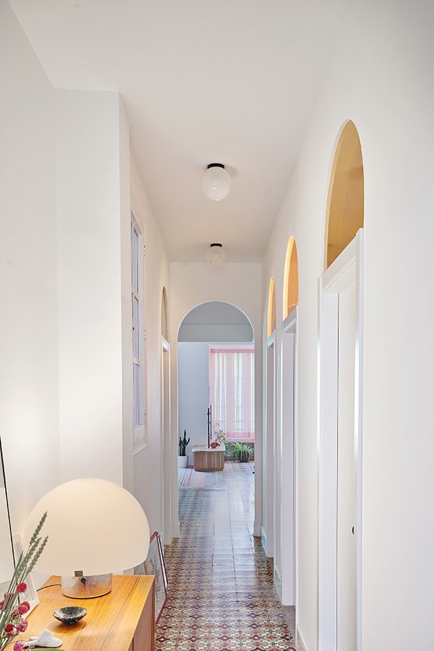 El pasillo que conduce a los dormitorios con arcos y cristales fijos sobre las puertas que dejan pasar la luz