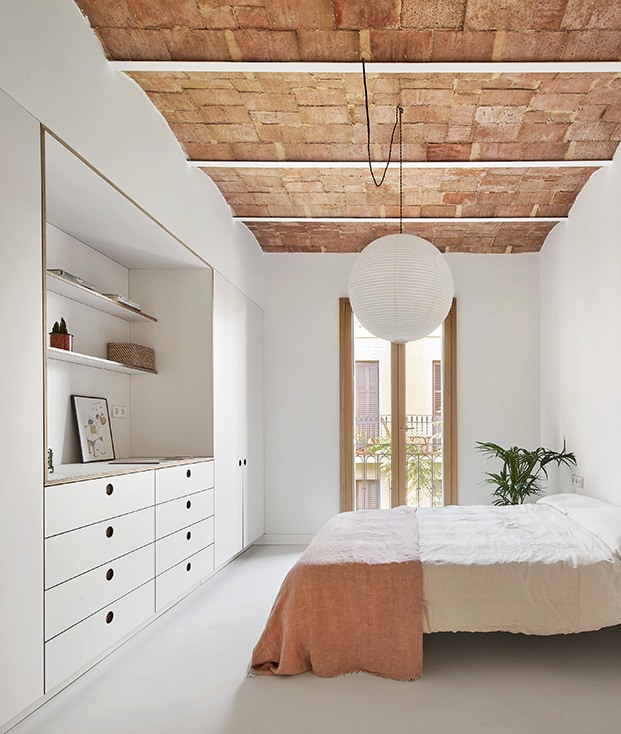 El dormitorio, sencillo, blanco, depurado y con el techo original de boveda catalana visto y protagonizando el espacio