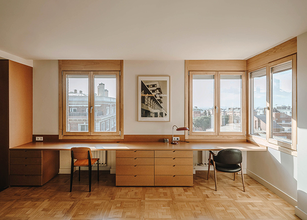 Un escritorio hecho en DM junto a las ventanas permite trabajar desde la misma habitación al tiempo que se disfrute de luz y vistas
