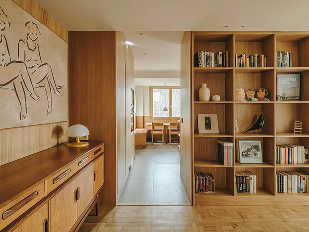 Un mueble en roble, diseño de Septiembre Arquitectura comunica los distintos ambientes de la zona de día  tras la reforma del ático en Sarrià