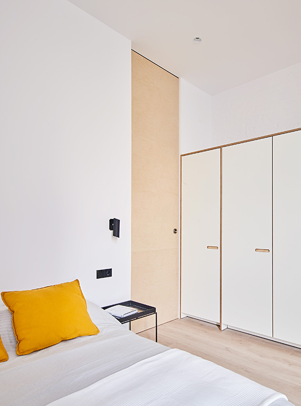 Una puerta corredera de grandes dimensiones separa el dormitorio de la zona de salón, comedor y cocina