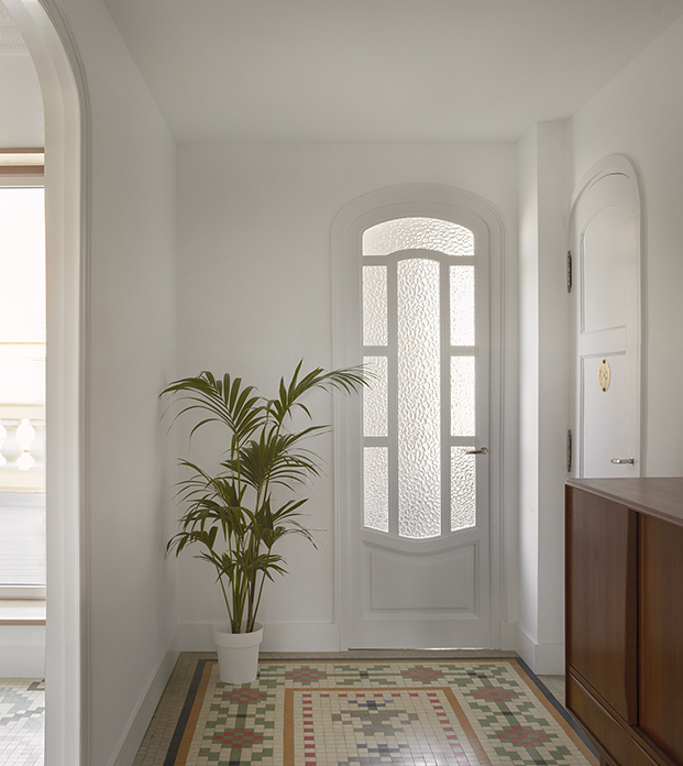 Las elegantes puertas curvas con cuarteros de cristal blancos son otras de las grandes protagonistas de este ático en Ruzafa