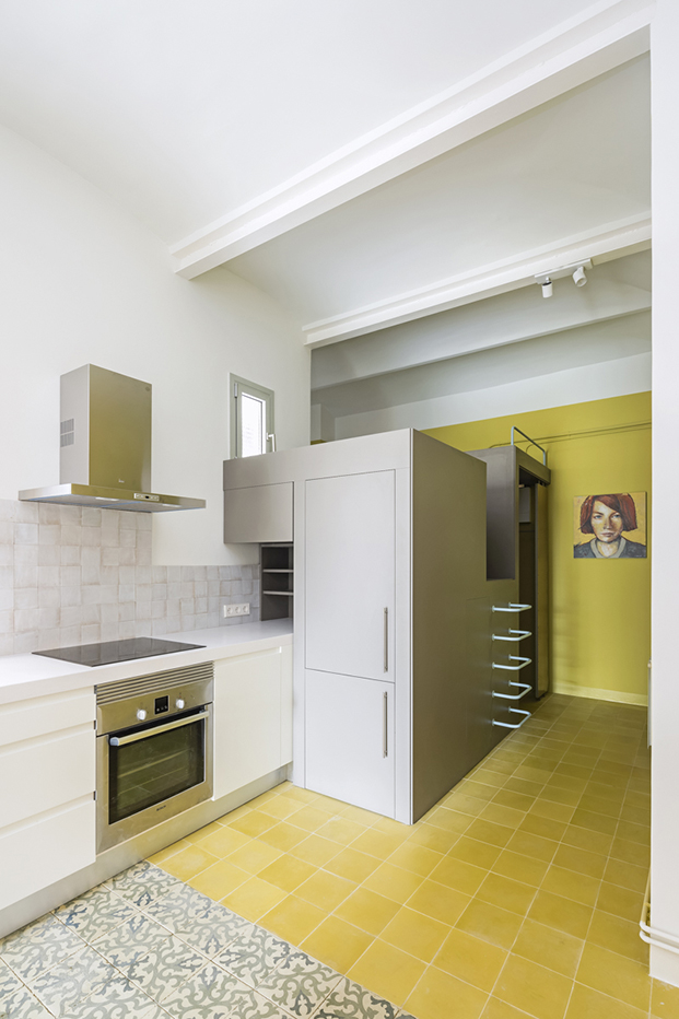 Una pieza en forma de cubo acoge parte de la cocina, la zona de almacenaje y el cuarto de baño. Unas escaleras permiten subir hasta el techo convertido en un altillo