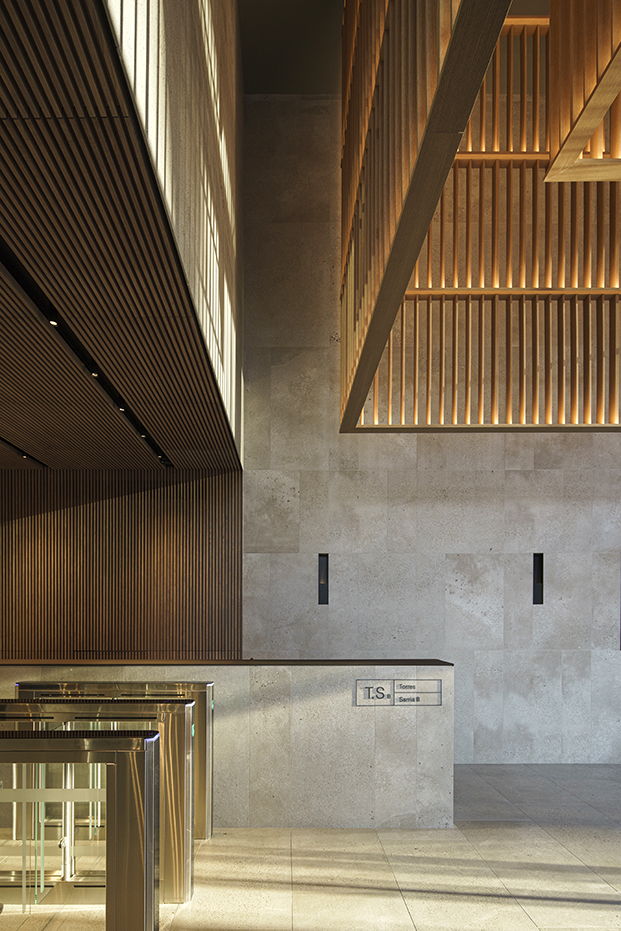 La madera iluminada con la luz del atardecer contrasta con la piedra gris que envuelve el edificio