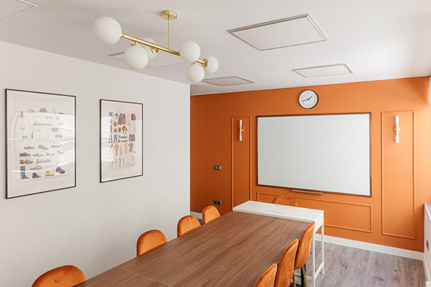 sala de trabajo con paredes naranjas y molduras, academia de español Madrid