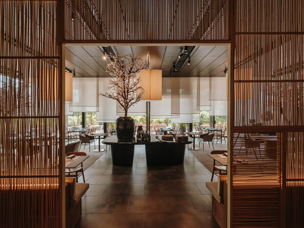 Paneles de fibras naturales actúan como telón de fondo del restaurante. Interiorismo de Sandra Tarruella.