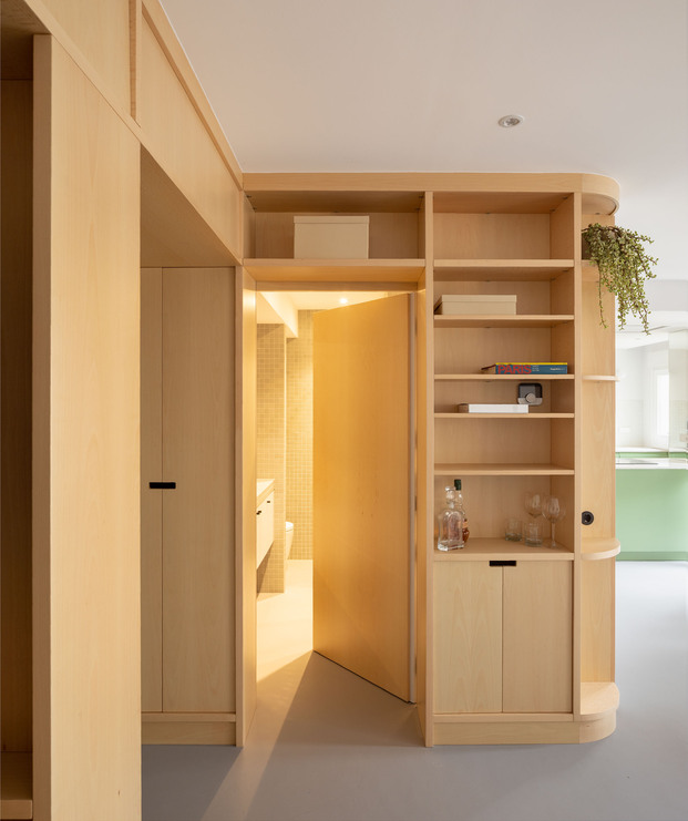 Mueble multifuncional de madera con puerta de acceso oculta integrada.
