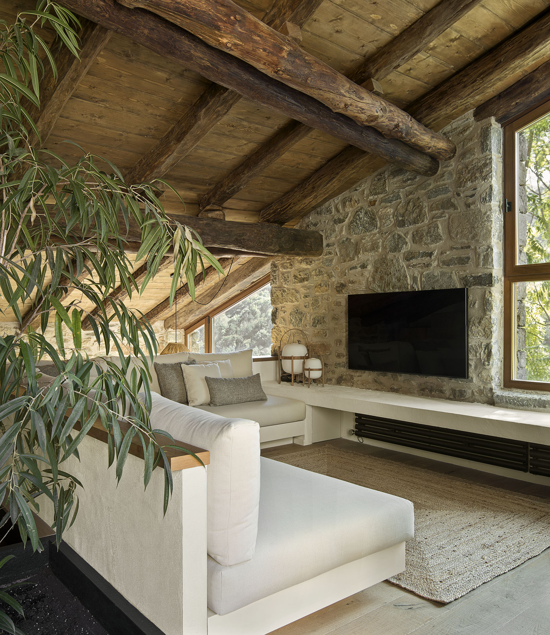 sofá de obra blanco y gris, salón con techo bajo de madera