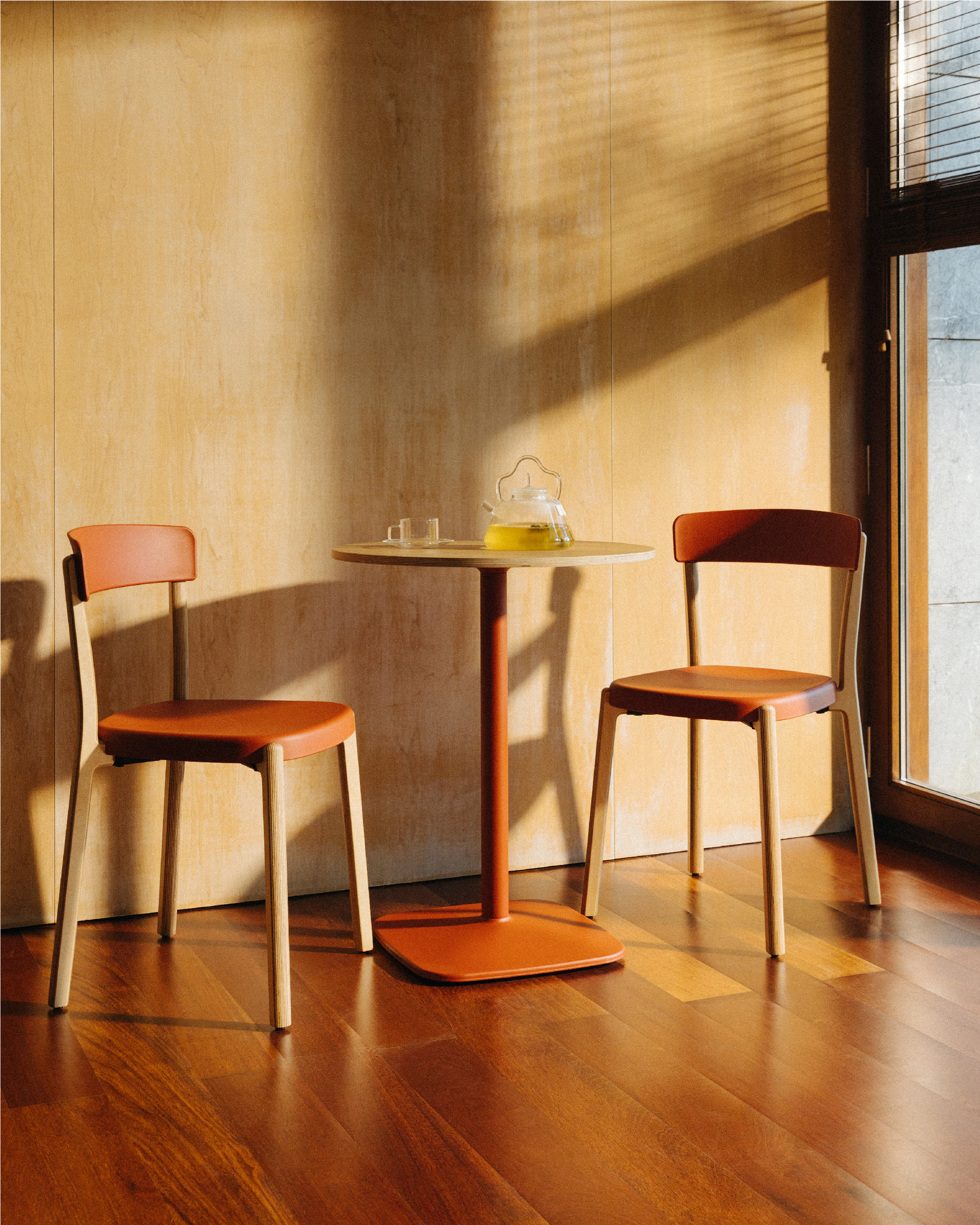 Dos sillas de madera con mesa redonda y pie cuadrado