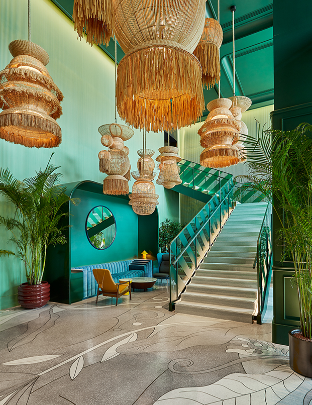 vestíbulo de hotel verde con lámparas de fibras vegetales y escalera, terrazo con dibujos