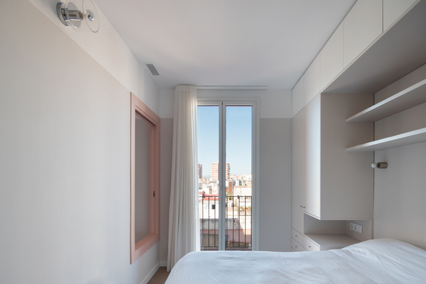 Dormitorio en tonos blancos y grises en una vivienda del barrio de Sants en Barcelona