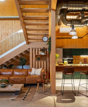 casa de madera con escaleras y sofa marrón de piel