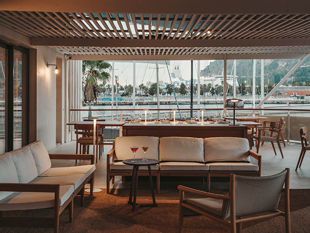 sofás de madera y terraza en restaurante en el puerto en barcelona