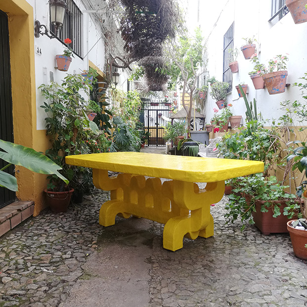 mesa amarilla de cerámica en jardín, diseño en sevilla