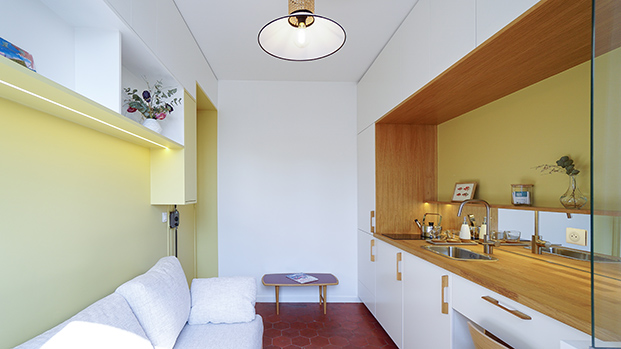 paredes amarillas en reforma de un mini estudio, cocina empotrada