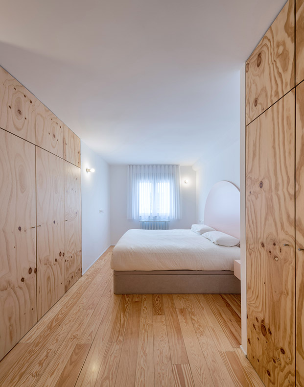 dormitorio con suelo y armarios de madera