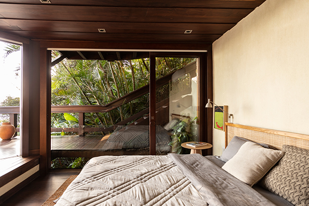 dormitorio con ventanal y techo de madera oscuro