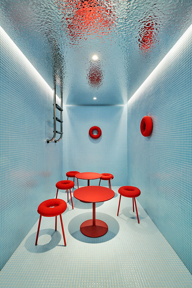 oficina con forma de piscina, taburetes y sillas rojos