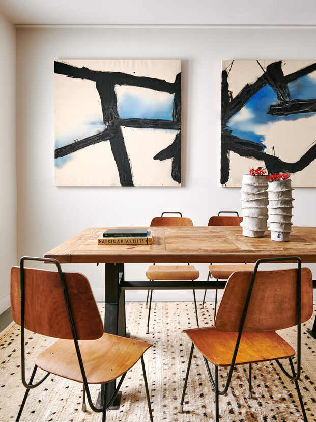 mesa de madera, cuadros abstractos, sillas de madera 