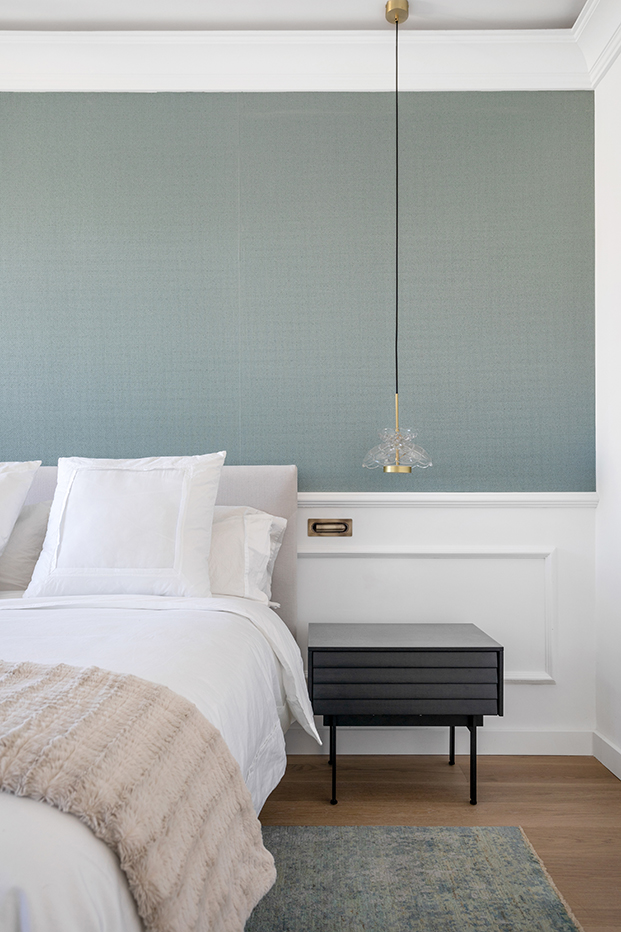 dormitorio con papel pintado turquesa y molduras blancas, lámpara colgante en el dormitorio
