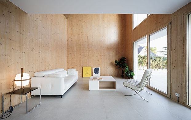 salón con paredes de madera y sofá blanco