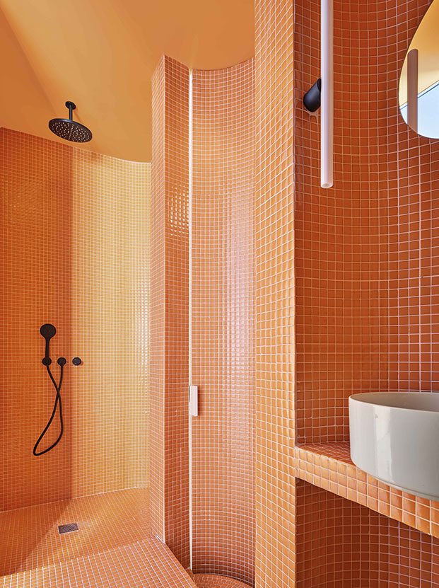Uno de los baños materializado en color naranja